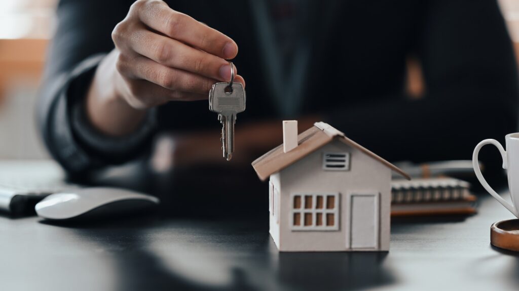 Cropped shot businessman holding house key. Insurance or loan real estate concept.